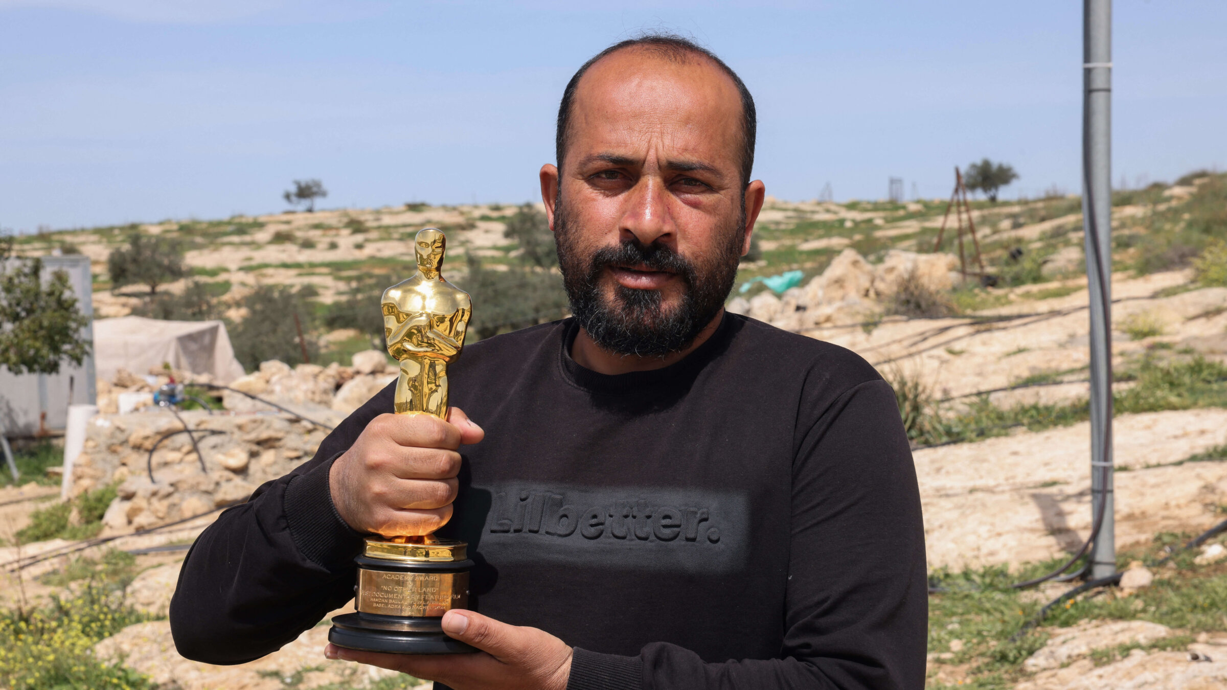 Palestinian filmmaker Hamdan Ballal poses for a picture with his Oscar, won for "No Other Land," as he recovers after Israeli settlers attacked him at home in his village of Susya in the south of the occupied West Bank on Mar. 26. 