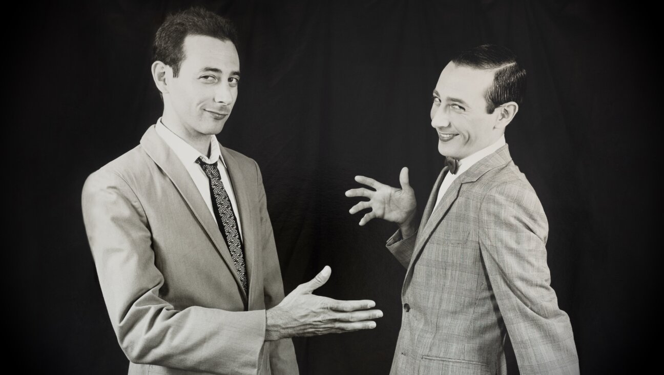 Paul Reubens (L) reaches out to shake the hand of his alter ego, Pee-wee Herman.